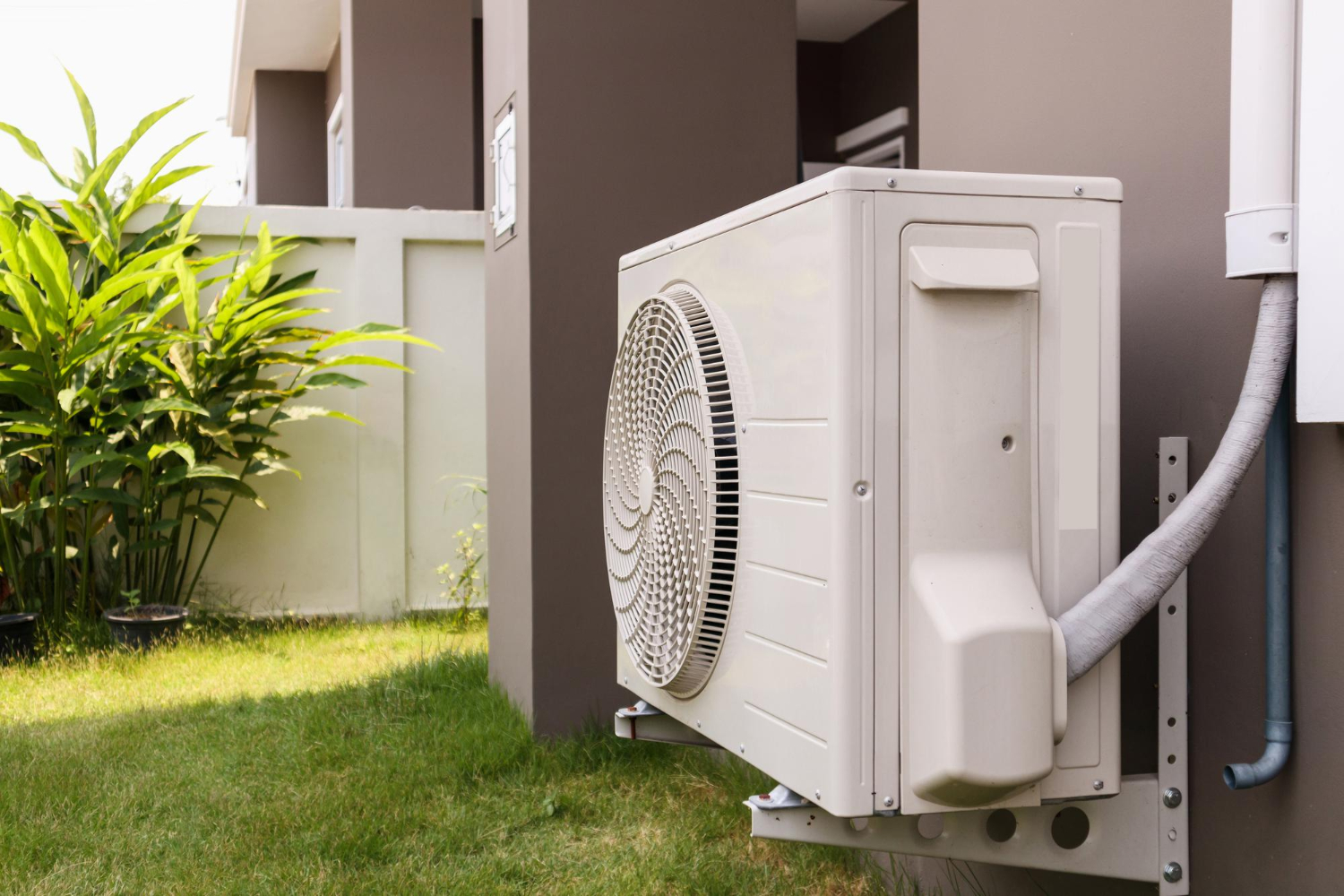 A white air conditioner outside of a house.