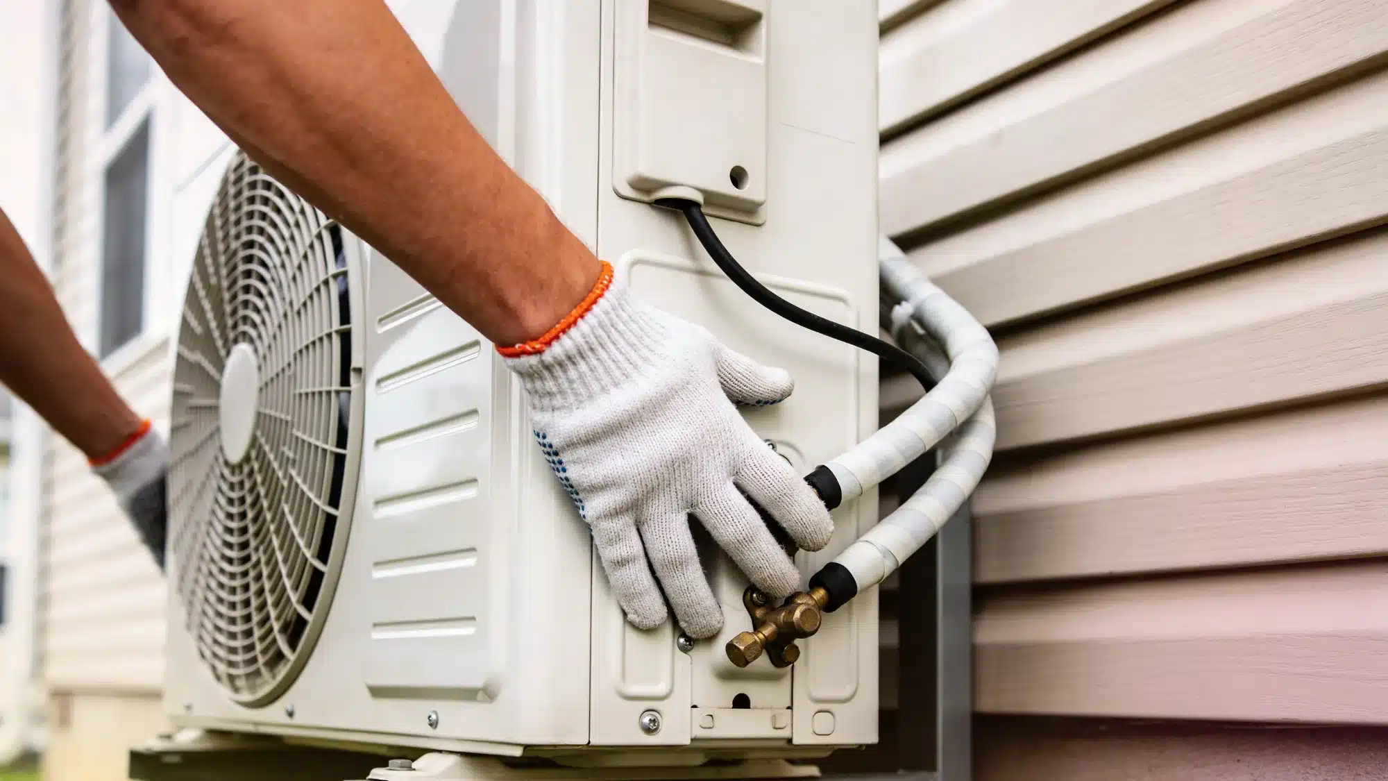Homeowner preparing air conditioning system for summer by cleaning outdoor unit and checking HVAC performance for efficient cooling